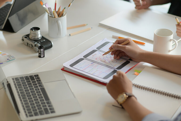 Cropped shot of young UX designer team working on smartphone application project with using digital tablet in modern office room.